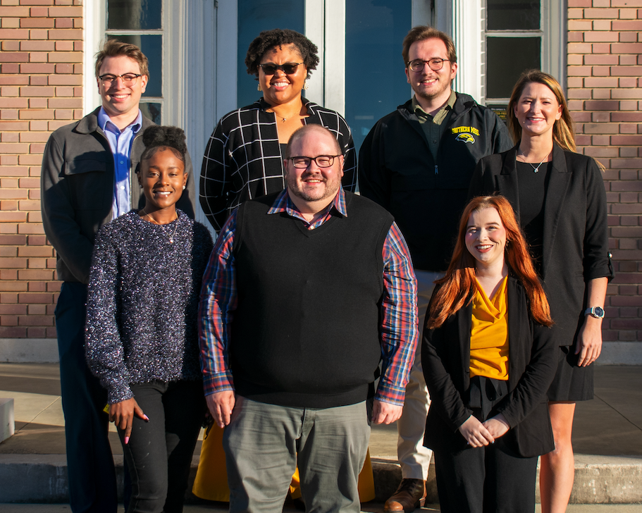 Roy Howard Community Journalism Center staff members include, bottom row, left to right, Morgan Gill, reporter and producer; Joshua Wilson, community liaison; and Jada Austin, administrative lead; and second row, left to right, Justin Glowacki, reporter and producer; Nichole Cyprian, director; Samuel Hughes, reporter and producer; and Whitney Argenbright, managing editor.